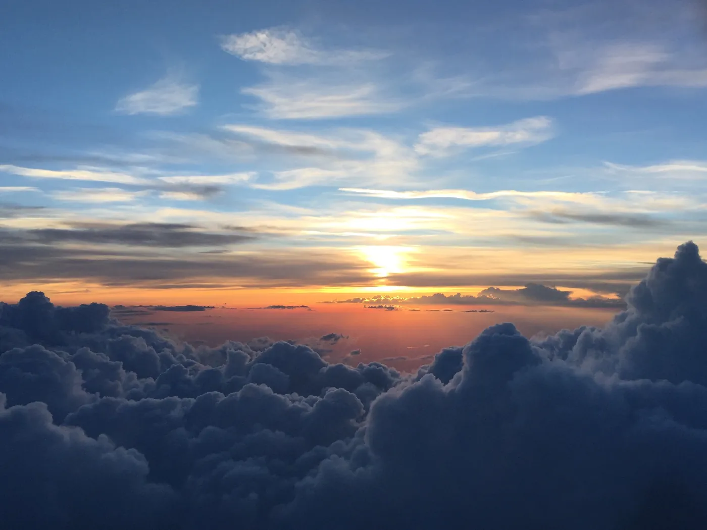 Puesta de sol anaranjada sobre un mar de nubes