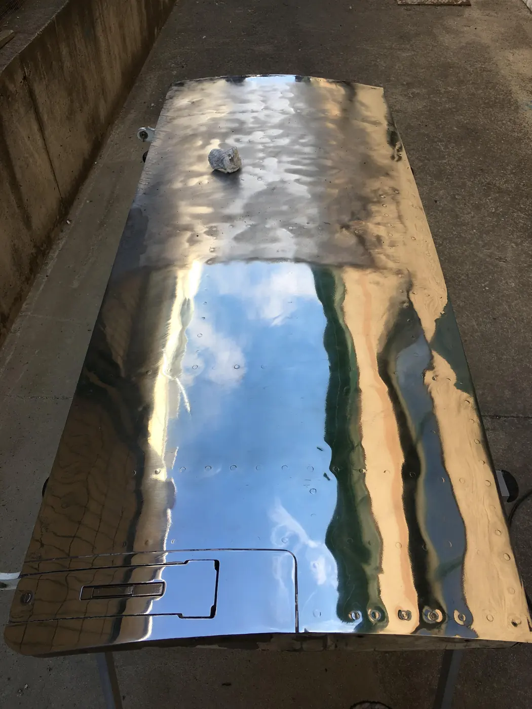Compuerta de carga pulida a espejo reflejando el cielo