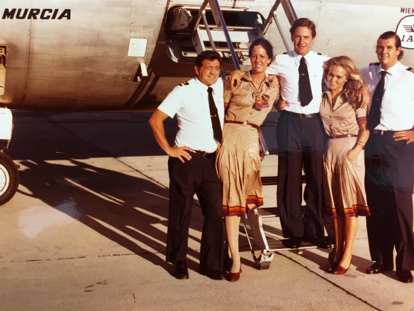 Fotografía de los años setenta con una tripulación posando junto a un avión que lleva el nombre Murcia en el morro